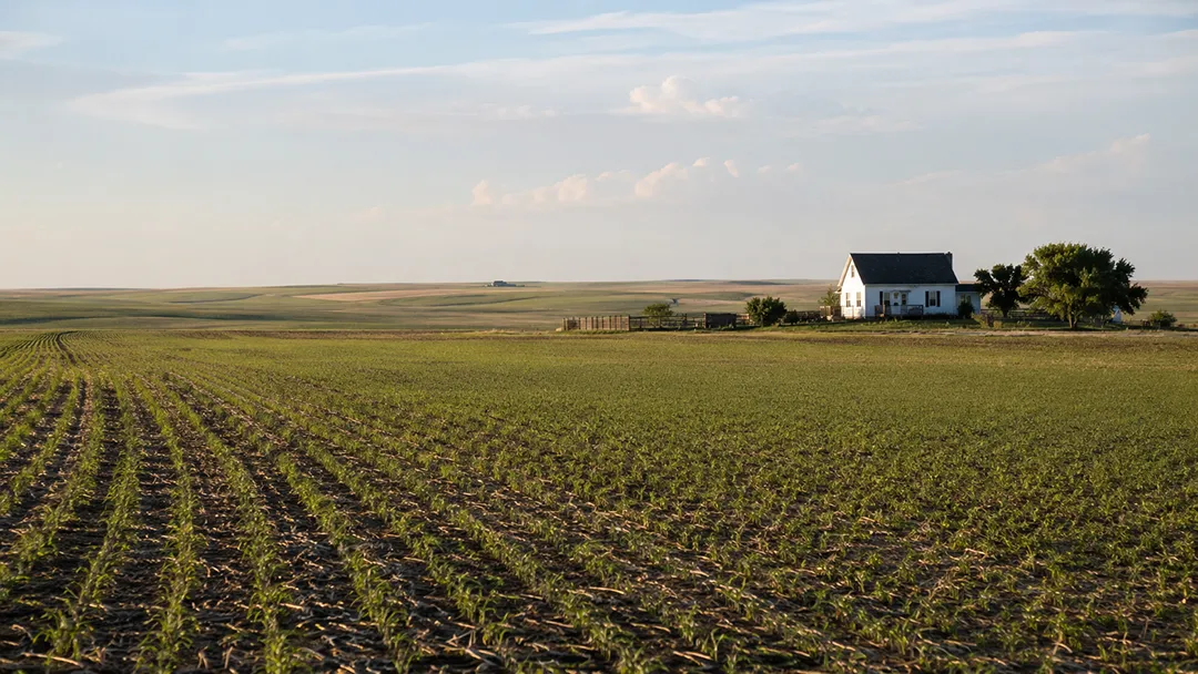 abandoned-mineral-rights-North-Dakota-farm-field-with-a-farmhouse-in-the-distance